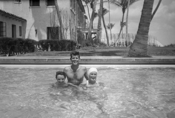 Ethel Skakel (L) stands with Jean Kennedy with John F. Kennedy in the pool at the Kennedy family home in Palm Beach, Florida, circa 1947.  Courtesy JFK Library