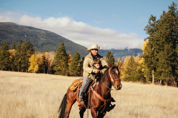 Kevin Costner riding a horse.